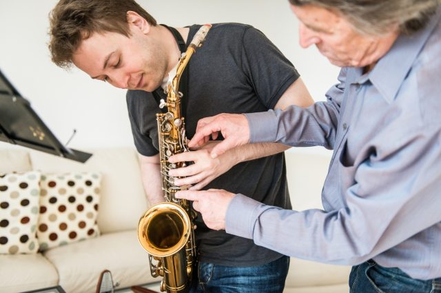 young-man-learning-to-play-saxophone-at-home-picture-id504870004